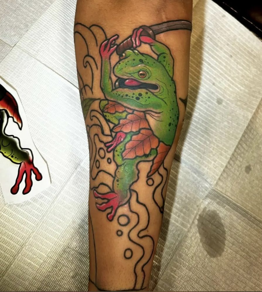 Green tree frog climbing among waves and an autumn leaf